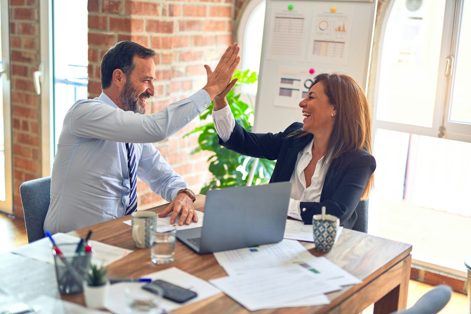 Two colleagues celebrating a successful outcome at work